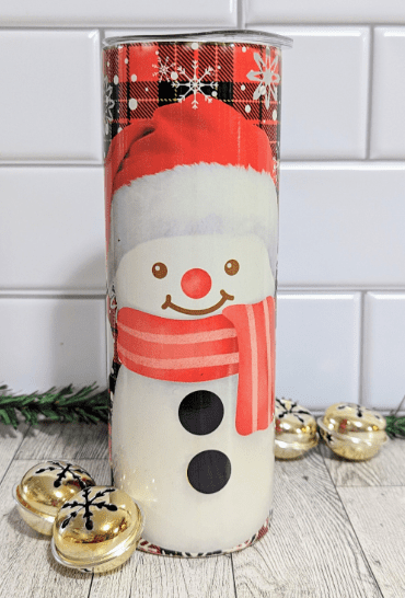 Snow man with santa hat on a stainless steel 20 oz tumbler. Background is a red and black tartan pattern with snowflakes.