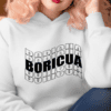woman wearing a white hoodie with the word Boricua echoed and written in a wavy font in black