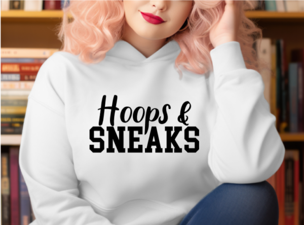 Woman wearing a white hoodie with the phrase "Hoops and Sneaks" written across the chest in black.