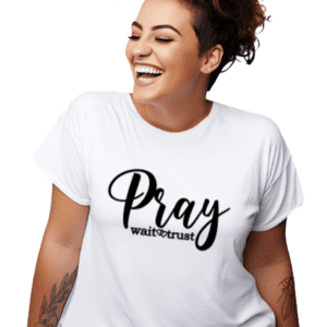 Woman wearing a white t-shirt with the phrase "Pray Wait Trust" written across the chest in black cursive lettering.
