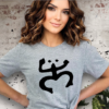 Woman wearing a gray t-shirt with a Taino Coqui on the chest in black.