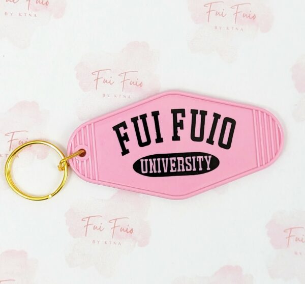 Pink Motel Keychain with gold tone ring. Phrase "Fui Fuio University" written on both sides in black.