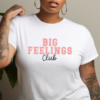 woman wearing a white t-shirt with the phrase "Big Feelings Club" written in pink and black.