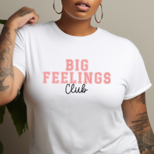 woman wearing a white t-shirt with the phrase "Big Feelings Club" written in pink and black.