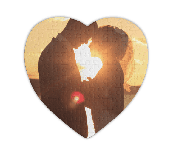 Heart shaped puzzle with the image of a bride and groom standing in front of the sun facing each other.