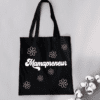 Black tote bag with the word "Mamapreneur" on the front with pink daisy flowers around it.