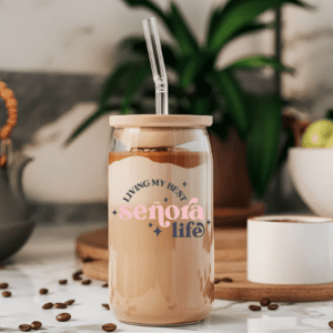 Glass Can (clear version) with the phrase "Living my best Senora Life" on the front in black and pink. it has a bamboo lid and glass straw.