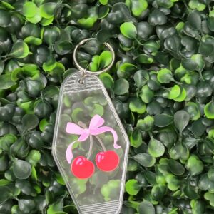 clear acrylic motel keychain with pink bow and cherry design . Transparent keychain.