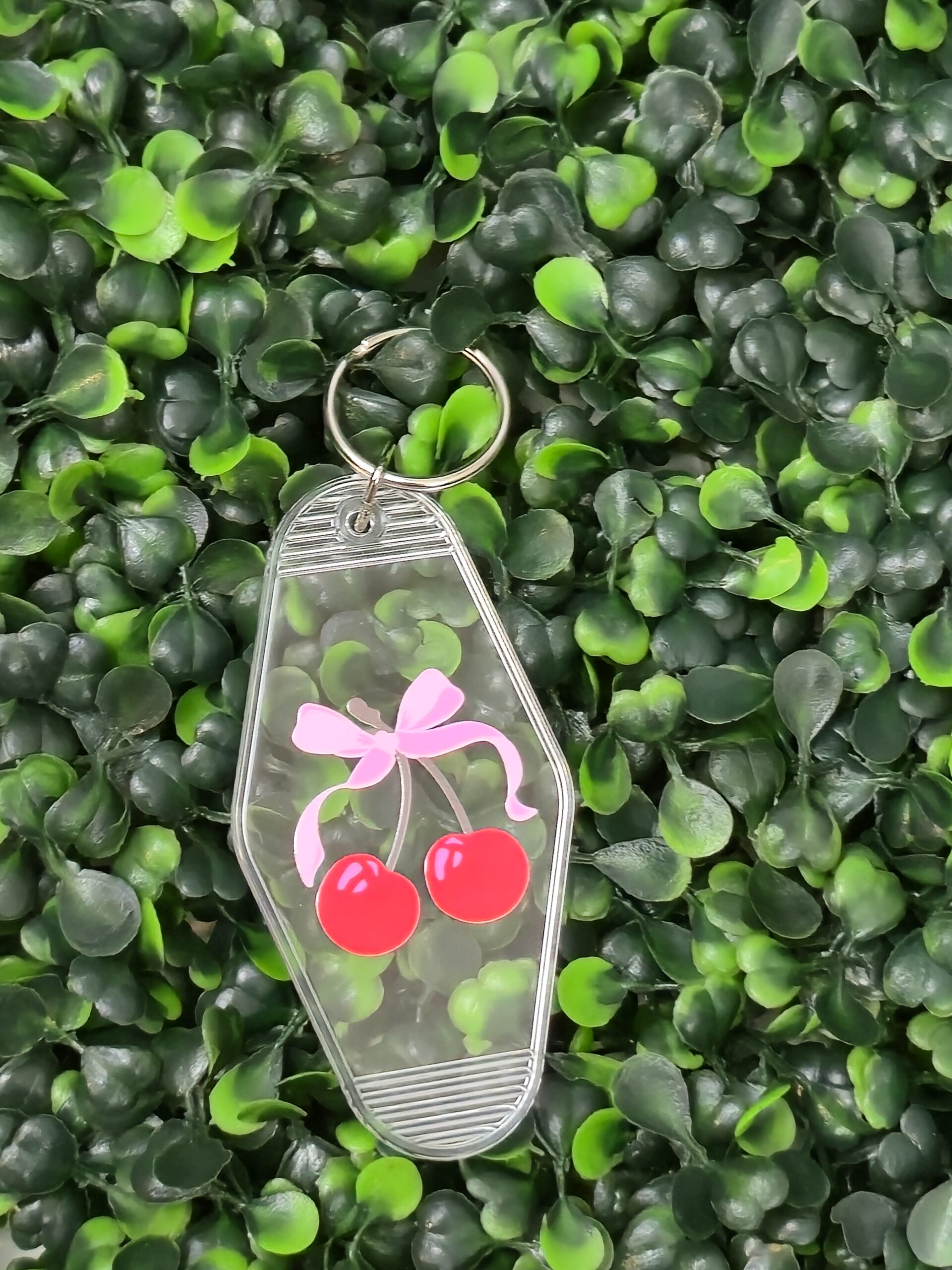 clear acrylic motel keychain with pink bow and cherry design . Transparent keychain.